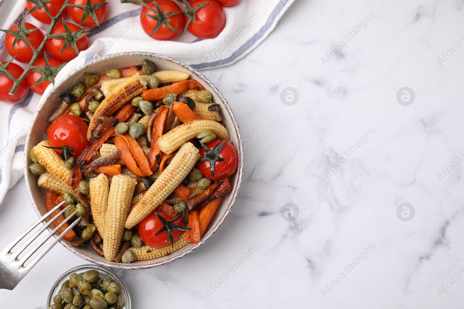 Photo of Tasty roasted baby corn with tomatoes and capers on white marble table, flat lay. Space for text