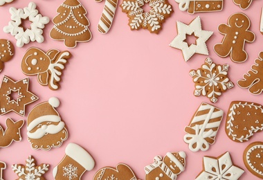 Photo of Frame made with different Christmas gingerbread cookies on pink background, top view. Space for text