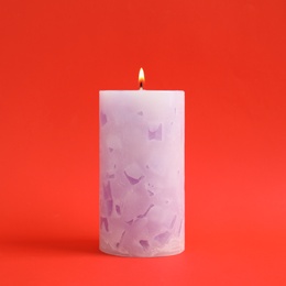 Alight scented wax candle on color background