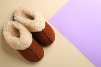 Pair of stylish soft slippers on color background, flat lay. Space for text