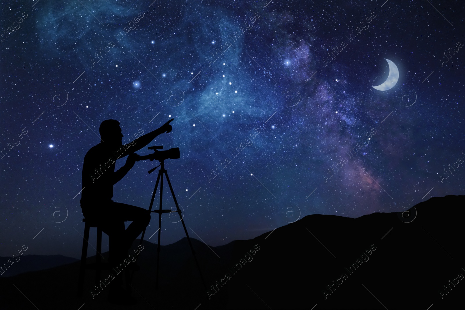 Image of Astronomer with telescope pointing at starry sky outdoors