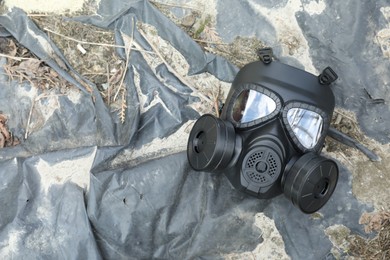 Photo of One gas mask on ground, top view. Space for text