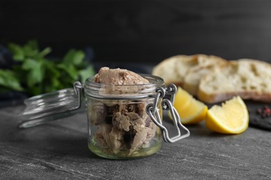 Photo of Glass jar of tasty cod liver on black table