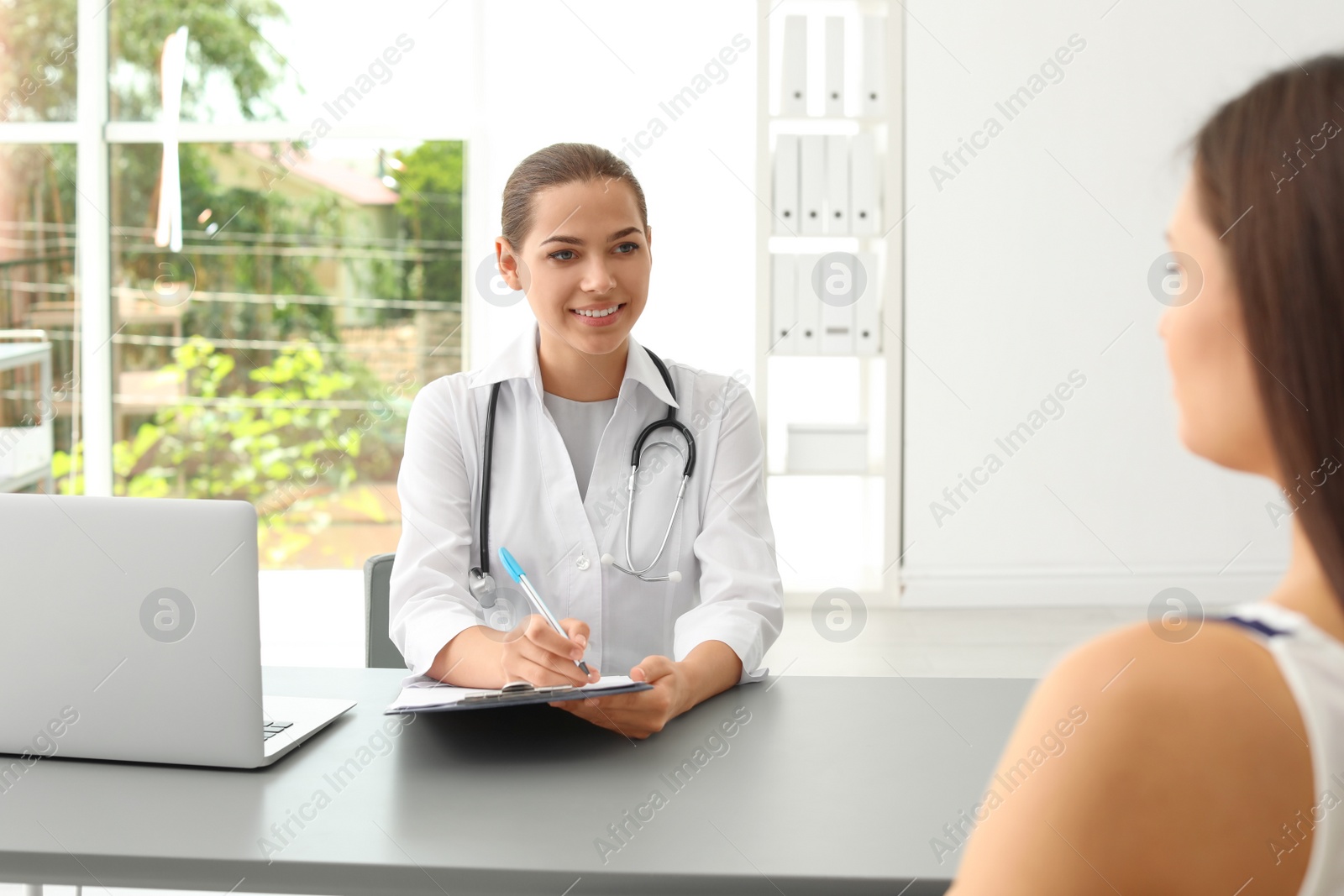 Photo of Young doctor speaking to patient in hospital