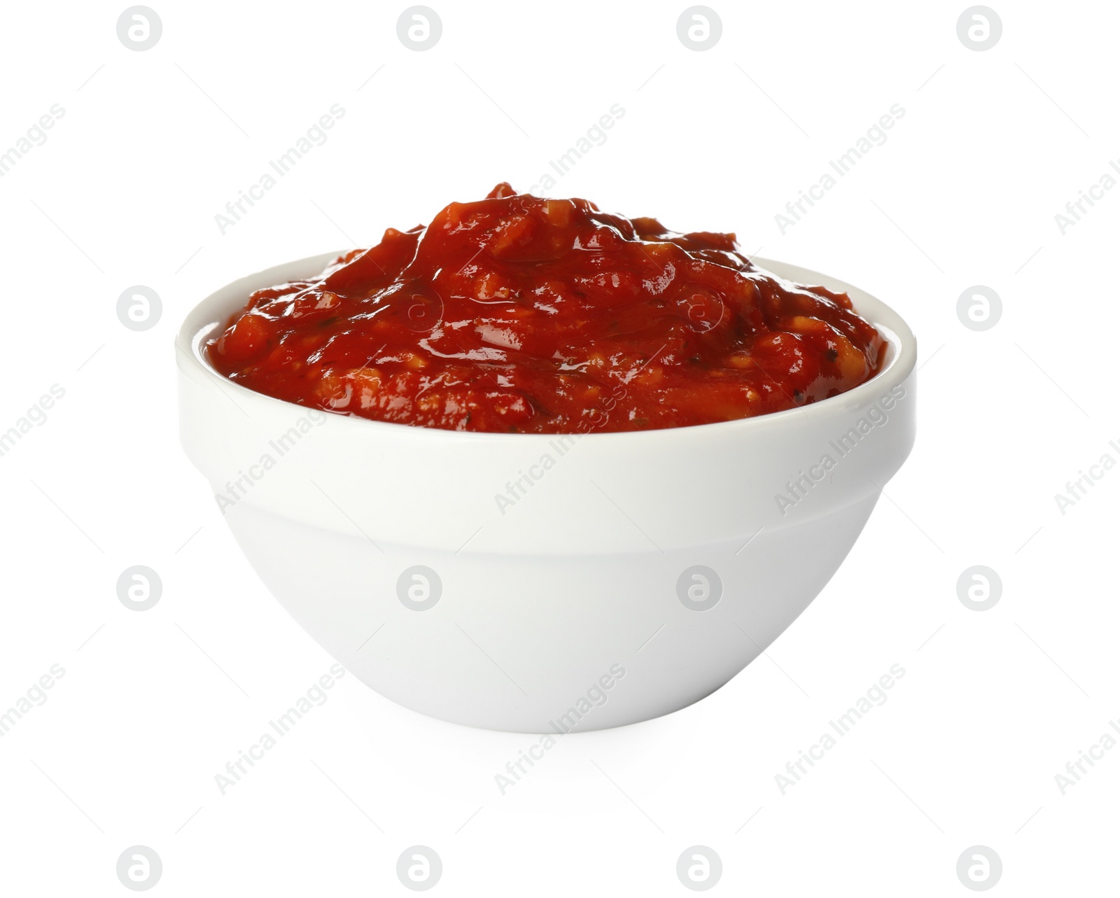 Photo of Delicious adjika sauce in bowl isolated on white