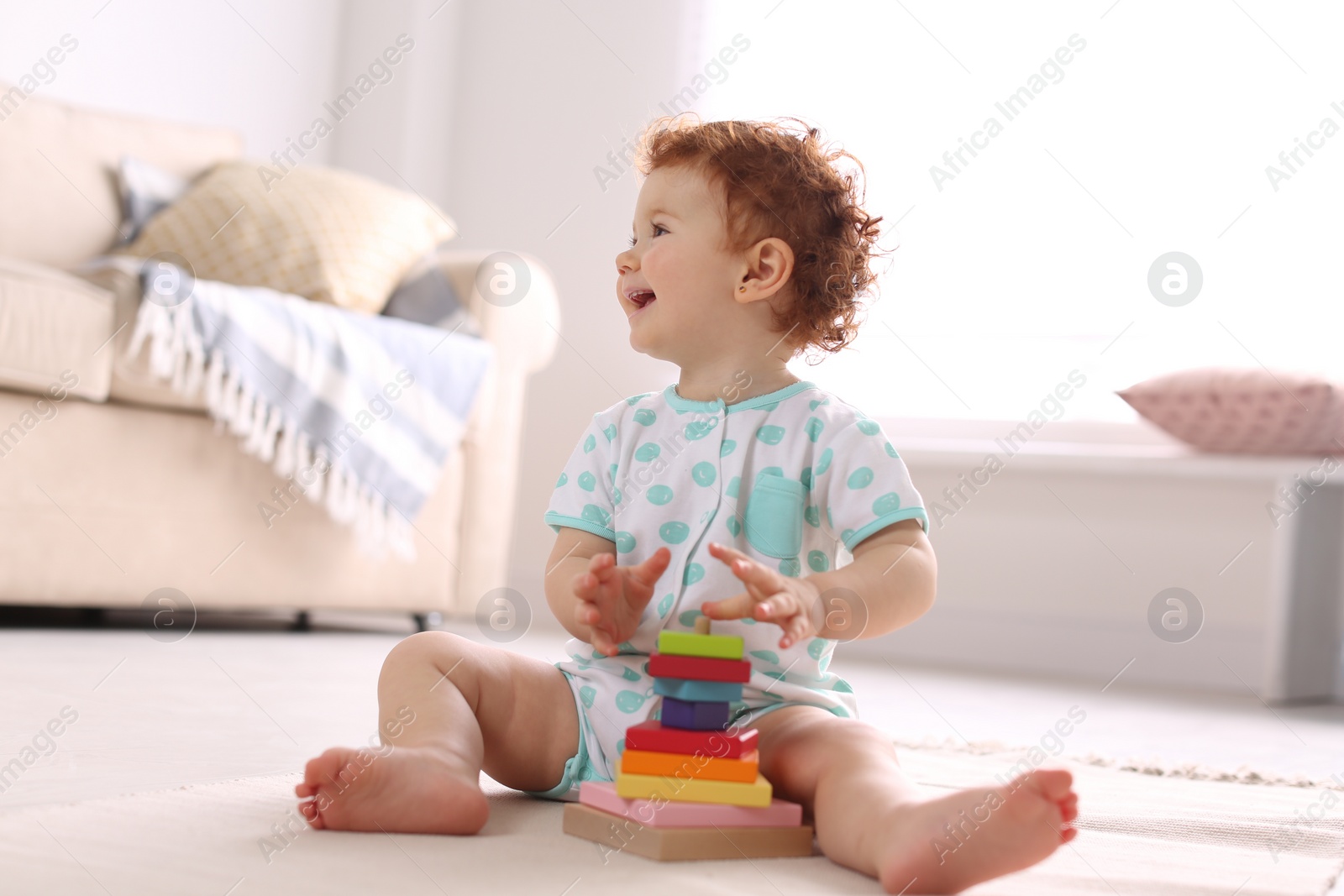 Photo of Cute little child playing with toy on floor at home