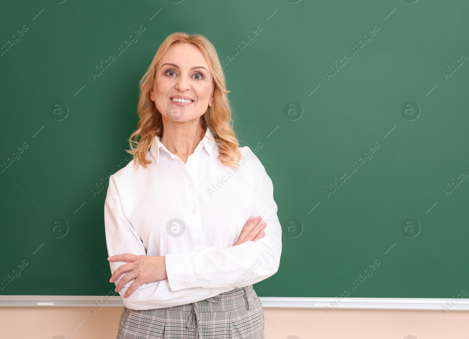 Photo of Happy professor near empty green board, space for text