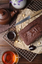 Photo of Flat lay composition with delicious chocolate sponge cake on wooden table