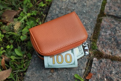 Photo of Brown leather purse on pavement outdoors, above view. Lost and found