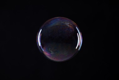 Photo of One beautiful soap bubble on black background