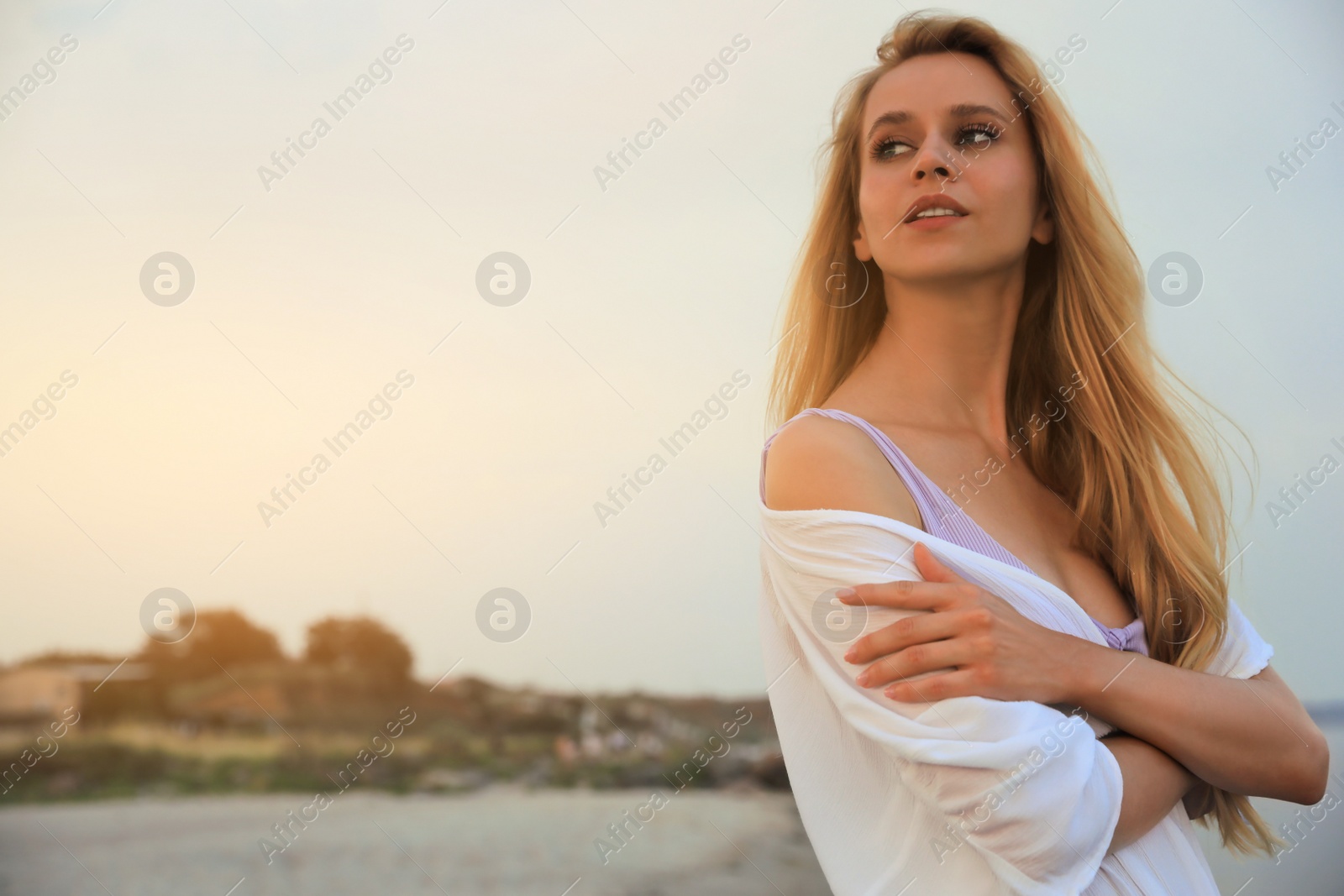 Photo of Beautiful young woman on beach in evening, space for text