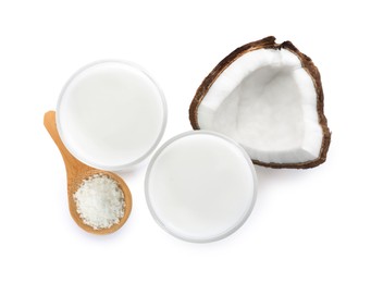 Photo of Glasses of delicious coconut milk, spoon with flakes and coconut isolated on white, top view