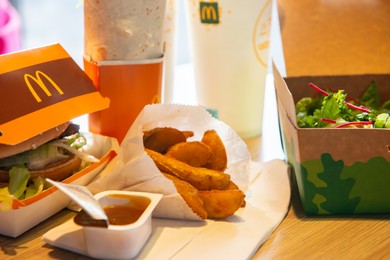 WARSAW, POLAND - SEPTEMBER 16, 2022: Big Mac hamburger, fried potatoes and cold drinks on table in McDonald's cafe