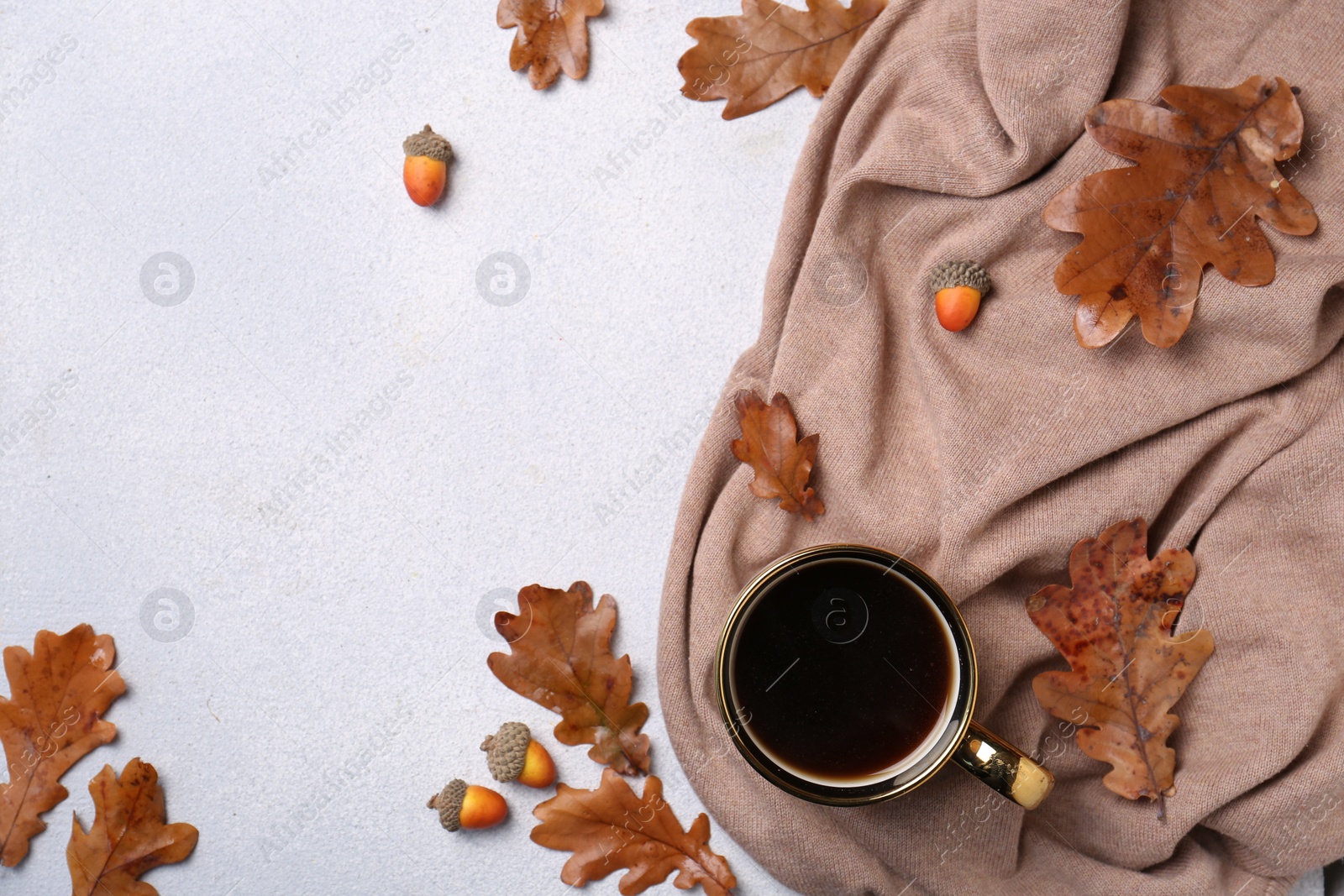 Photo of Flat lay composition with cup of hot drink and autumn leaves on light grey textured table. Space for text