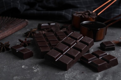 Photo of Tasty dark chocolate bars on grey table