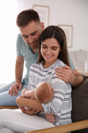 Photo of Happy couple with their newborn baby at home