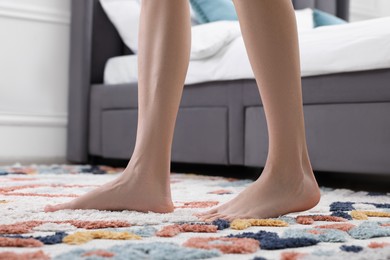 Woman walking on carpet with pattern at home, closeup