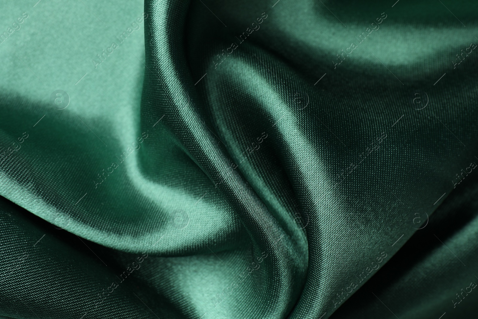 Photo of Crumpled green silk fabric as background, closeup