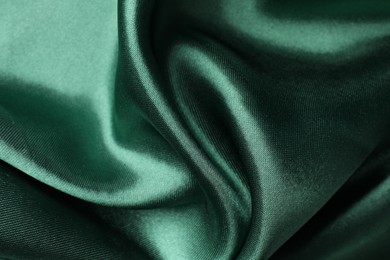 Crumpled green silk fabric as background, closeup