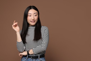 Photo of Portrait of smiling woman on brown background. Space for text