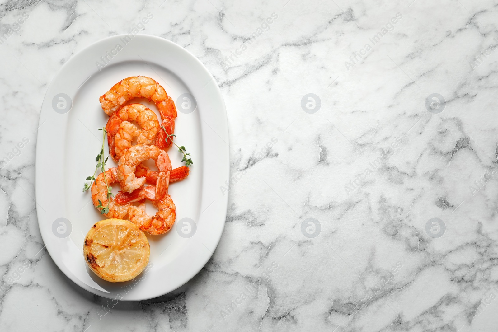 Photo of Plate with delicious fried shrimps and lemon on light background, top view