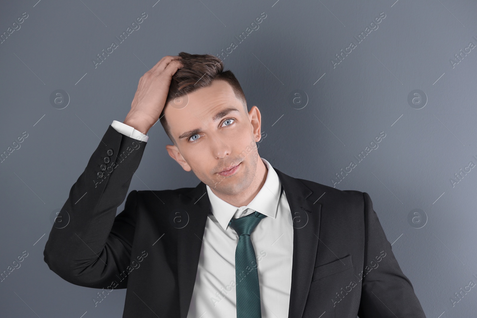 Photo of Portrait of young man with beautiful hair on grey background