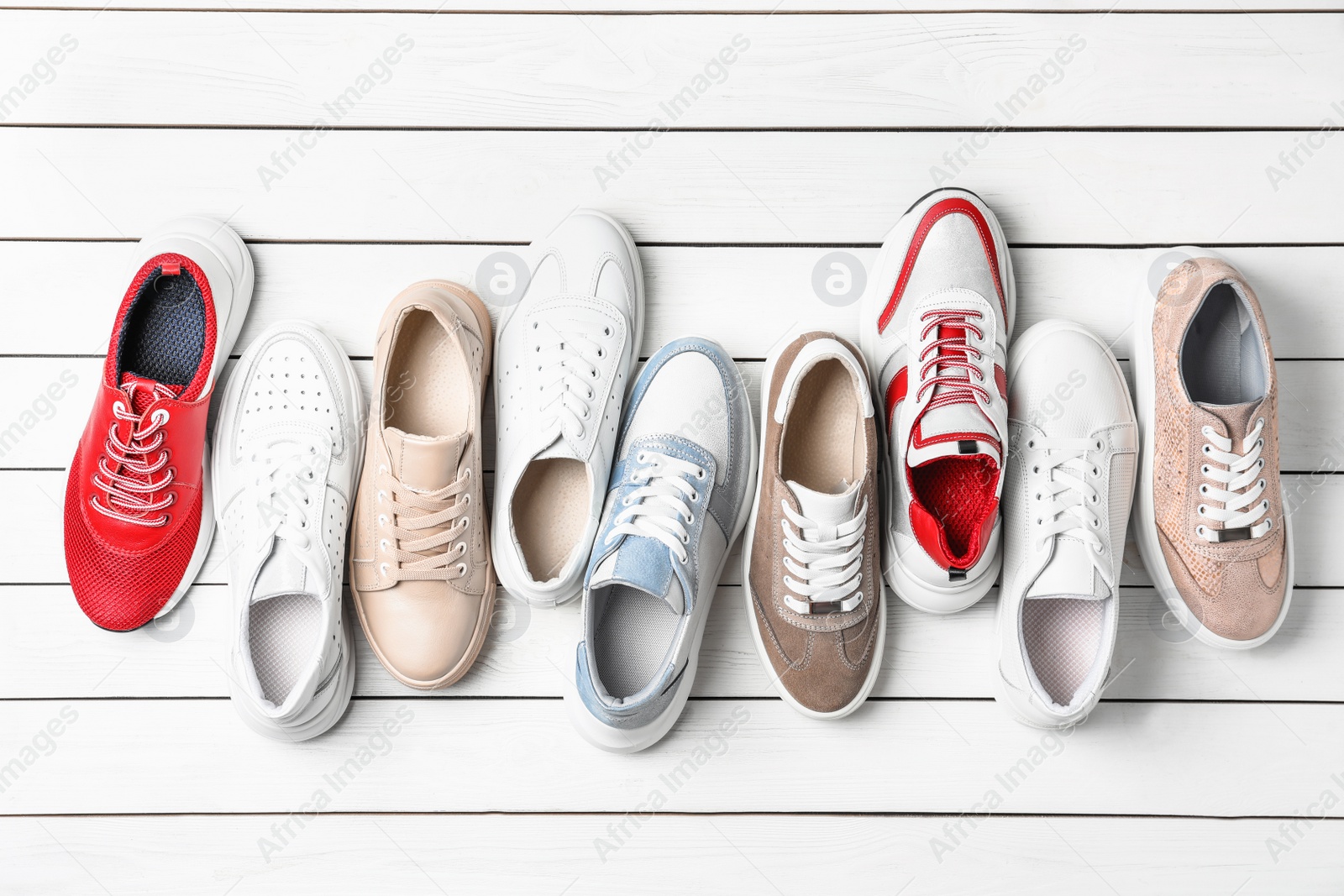 Photo of Flat lay composition with stylish shoes on white wooden table