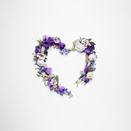 Photo of Beautiful heart made of different flowers on white background, top view