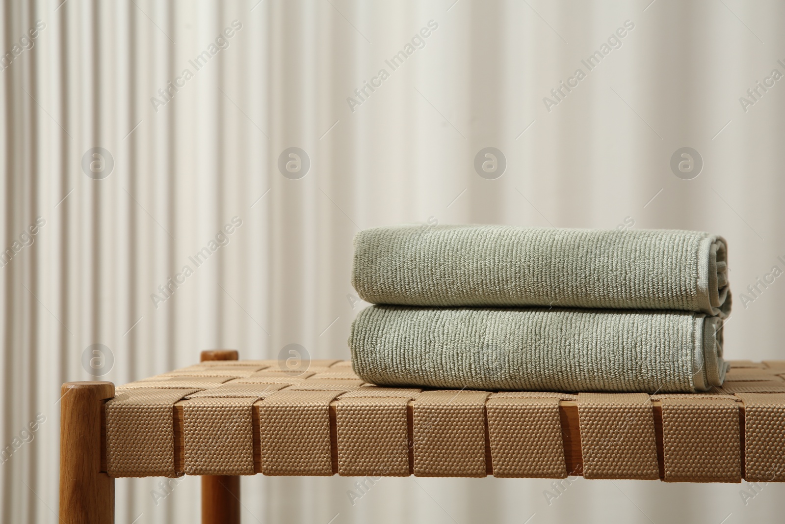 Photo of Soft towels on bench indoors, space for text