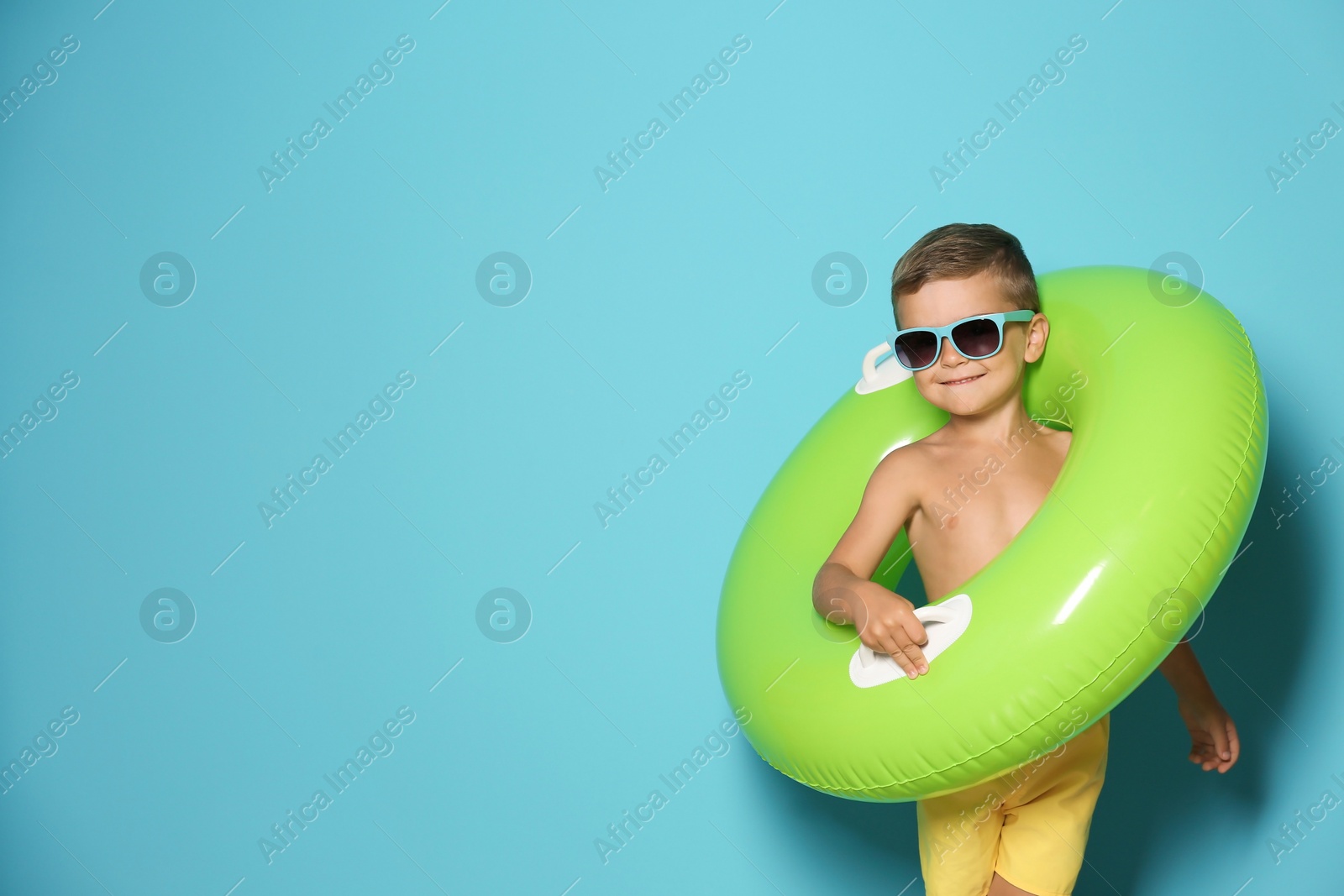 Photo of Cute little boy with inflatable ring on color background