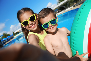 Happy children taking selfie near swimming pool. Summer vacation