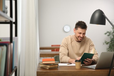 Man reading book at table in library