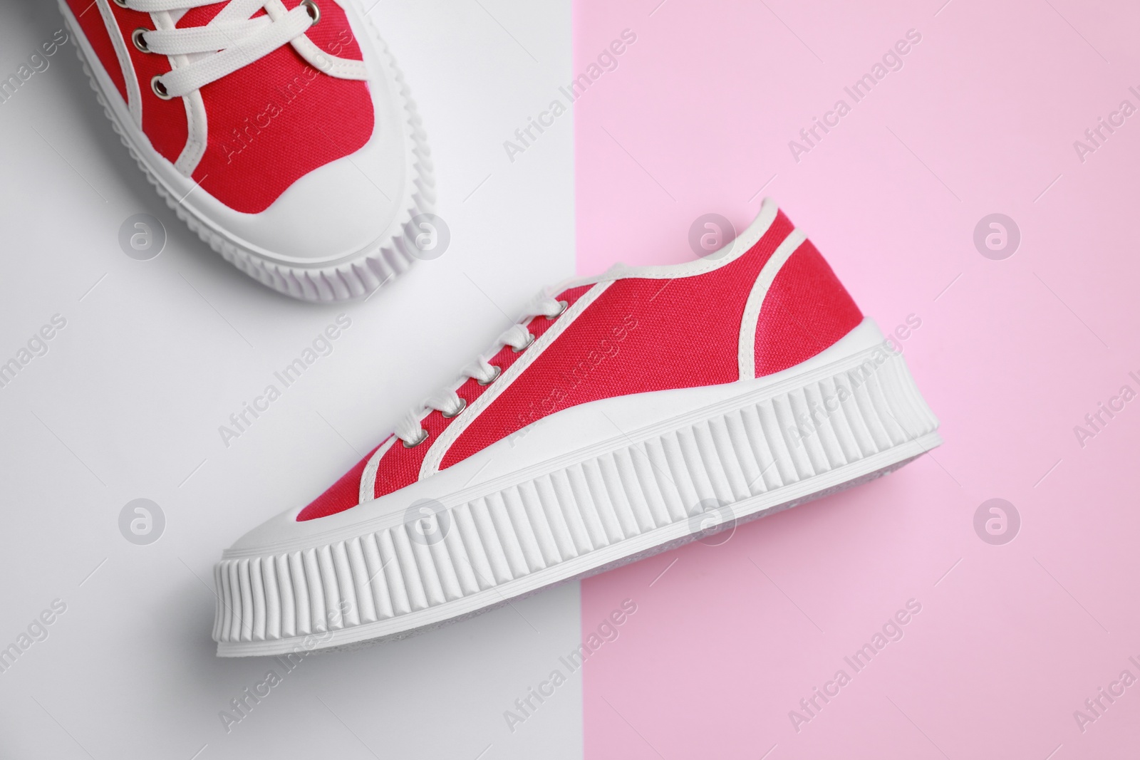 Photo of Pair of red classic old school sneakers on color background, flat lay