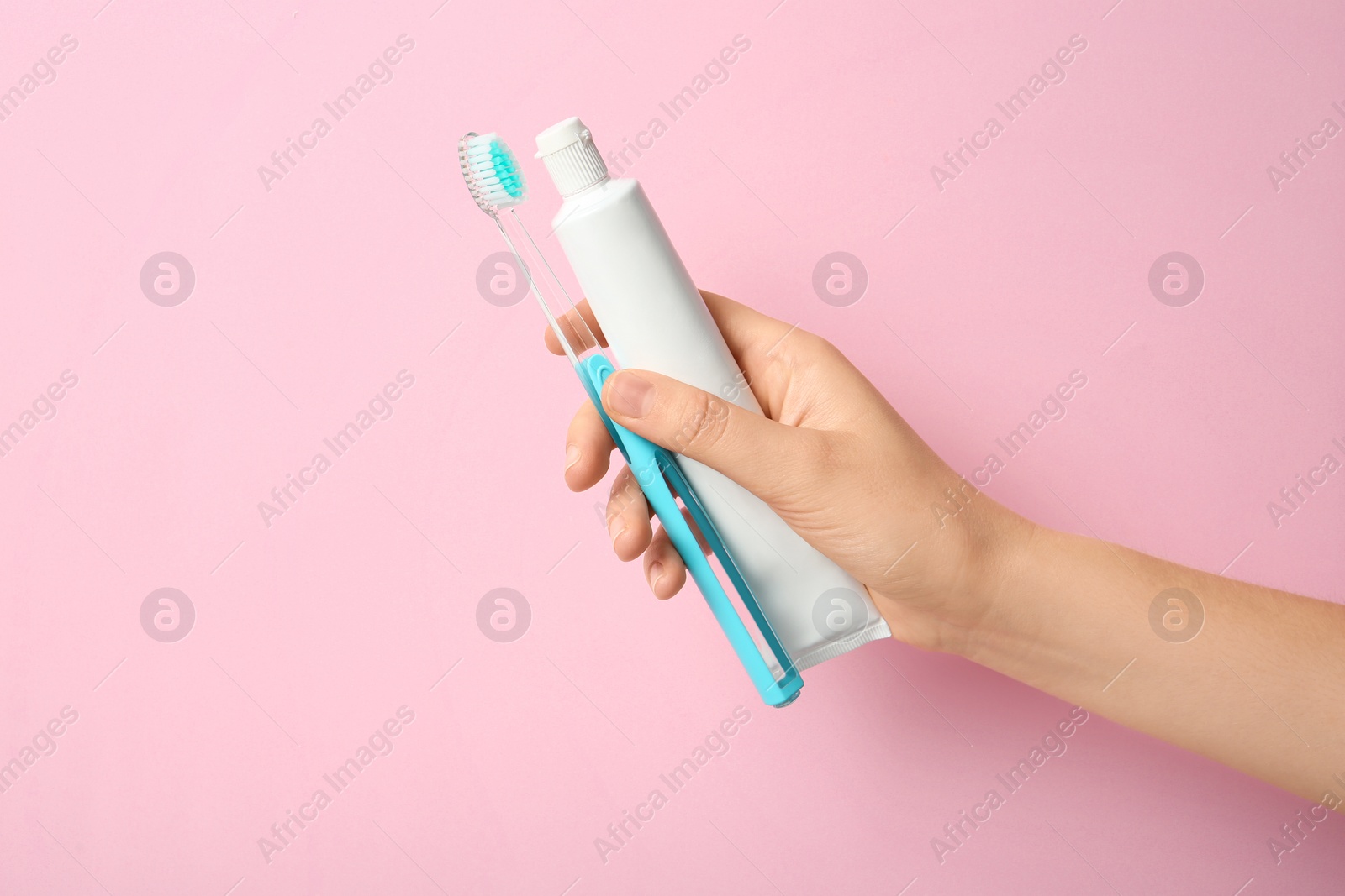 Photo of Woman holding toothbrush and paste against color background. Dental care