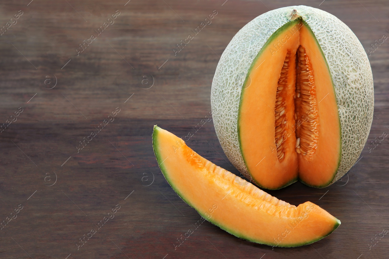 Photo of Cut delicious ripe melon on wooden table, space for text