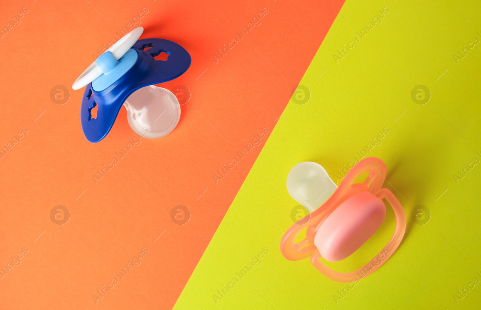 Photo of Baby pacifiers on color background, flat lay