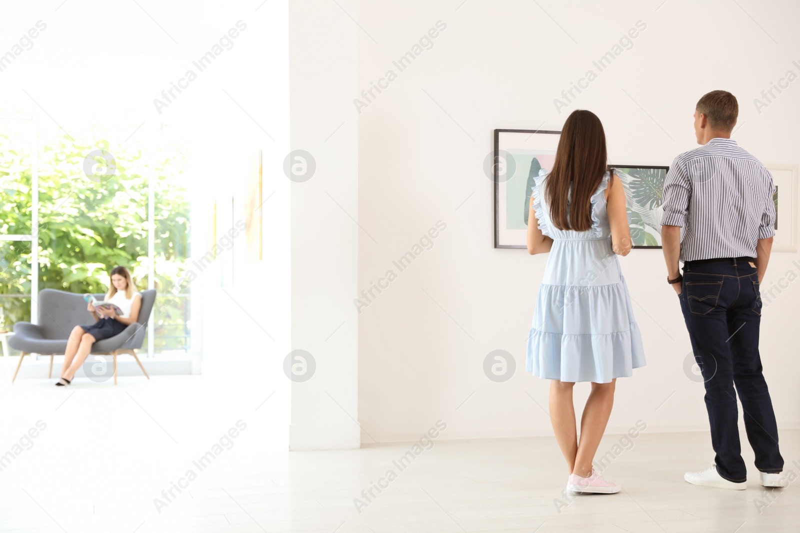 Photo of Young couple at exhibition in art gallery