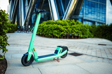 Photo of Green electric scooter on street near bushes outdoors