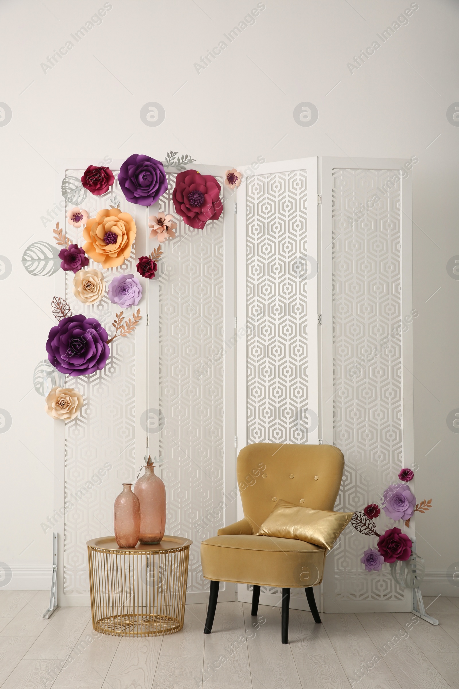 Photo of Beautiful photo zone with folding screen, chair and floral decor indoors