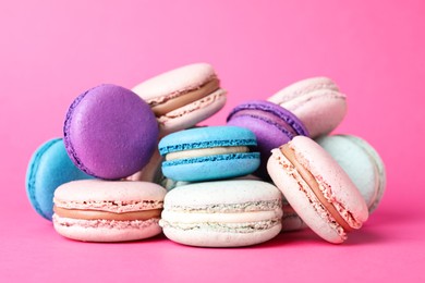 Photo of Pile of delicious colorful macarons on pink background