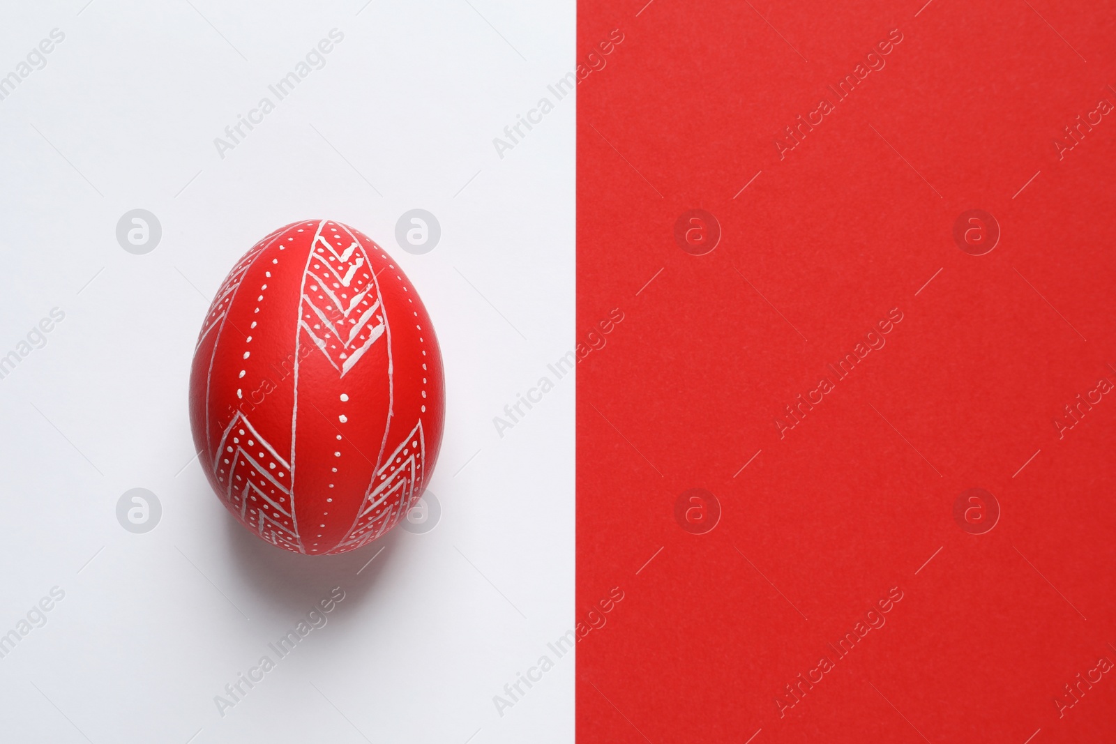 Photo of Creative red painted Easter egg on color background, top view. Space for text