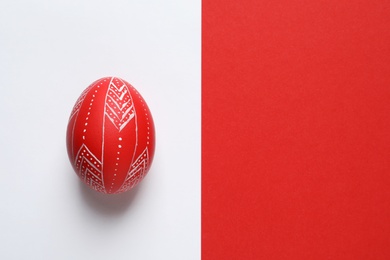 Photo of Creative red painted Easter egg on color background, top view. Space for text