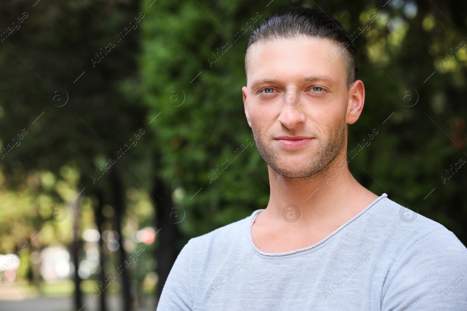 Photo of Portrait of handsome young man in park, space for text