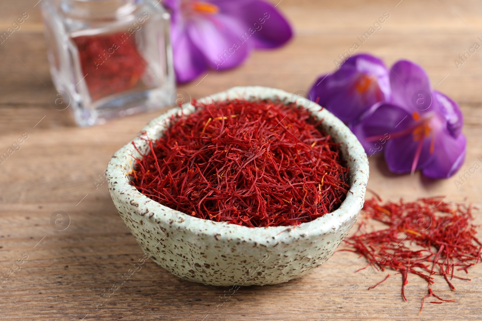 Photo of Dried saffron and crocus flowers on wooden table