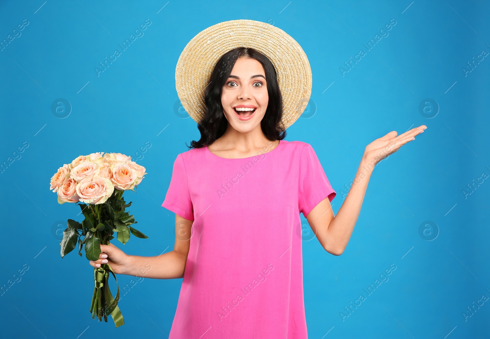 Photo of Portrait of emotional woman with beautiful bouquet on light blue background