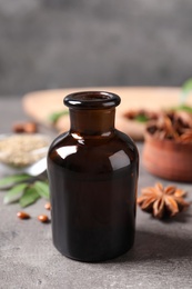 Photo of Bottle of anise essential oil on grey table