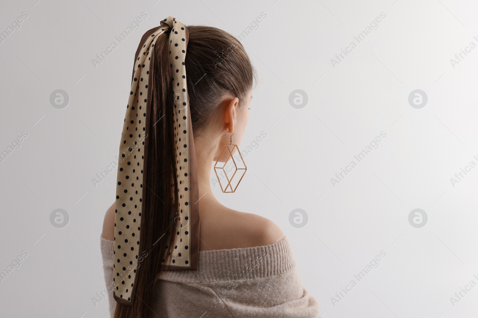 Photo of Young woman with stylish bandana on light background