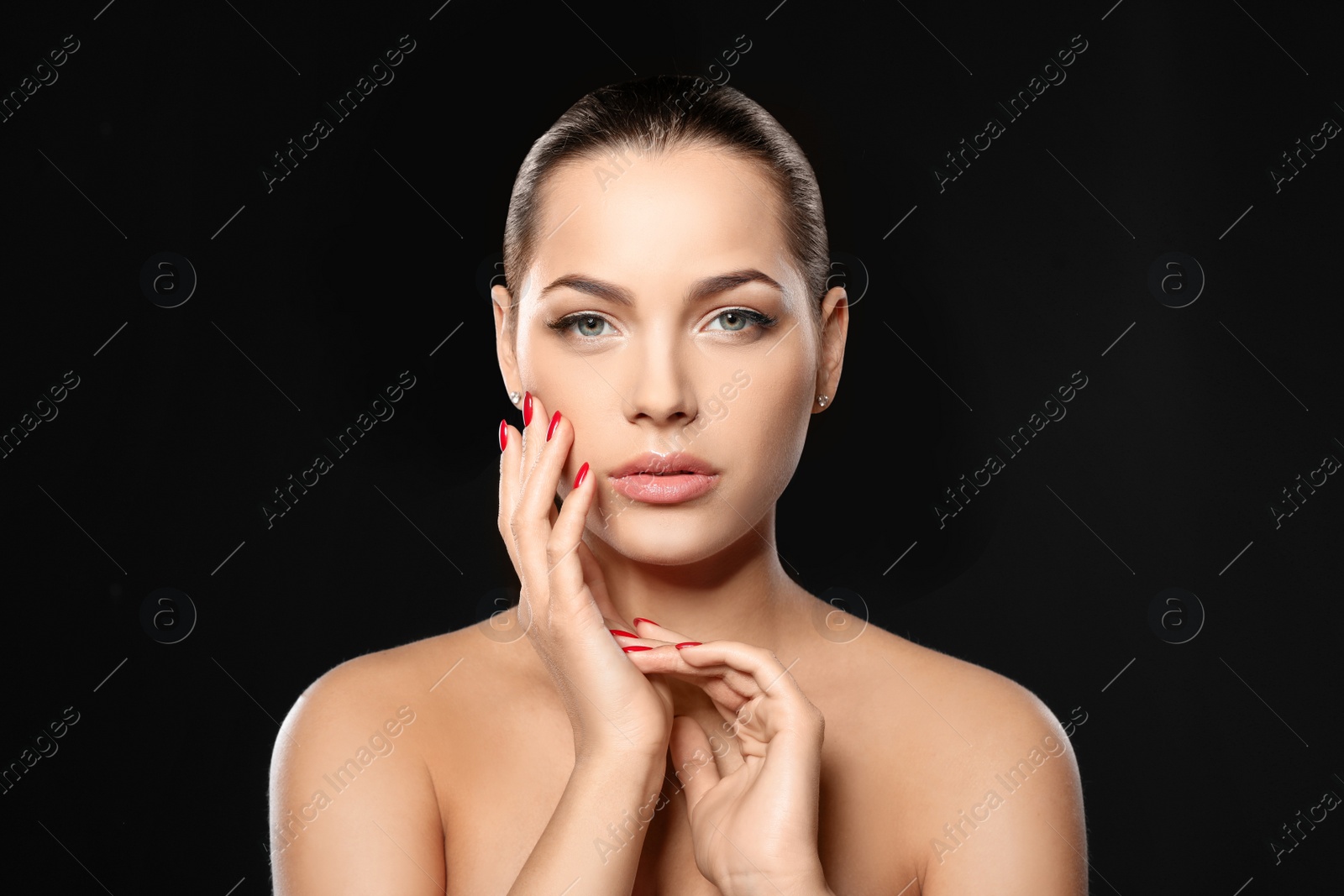 Photo of Portrait of beautiful young woman with bright manicure on black background. Nail polish trends