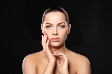 Photo of Portrait of beautiful young woman with bright manicure on black background. Nail polish trends