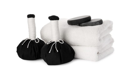 Photo of Spa composition with stacked towels, stones and herbal massage bags on white background